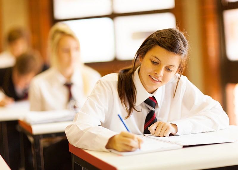 Student in uniform doing classwork
