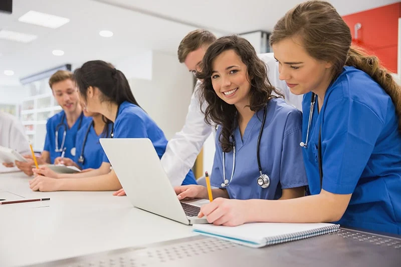 Medical students in scrubs studying together