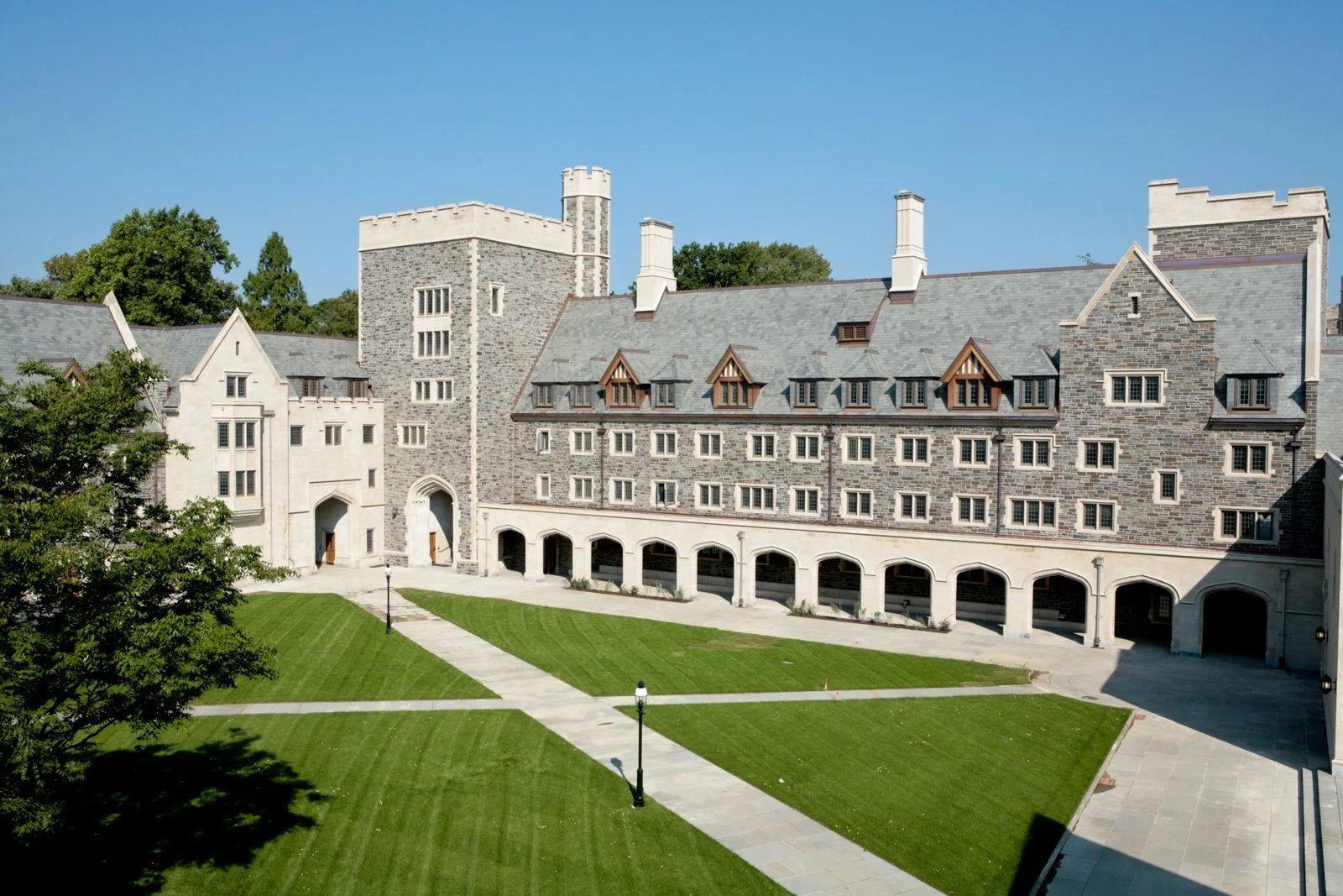Stone school buildings around a green lawn
